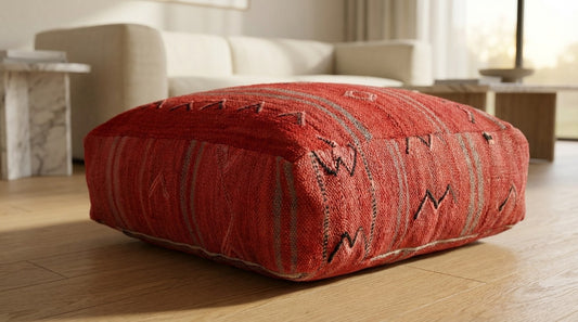 Close up view of vintage Moroccan deep red kilim pouf in contemporary living room
