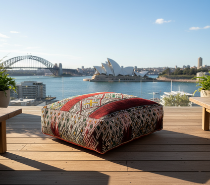 view of vintage Moroccan kilim pouf burgundy multi on terrace overlooking Sydney opera house