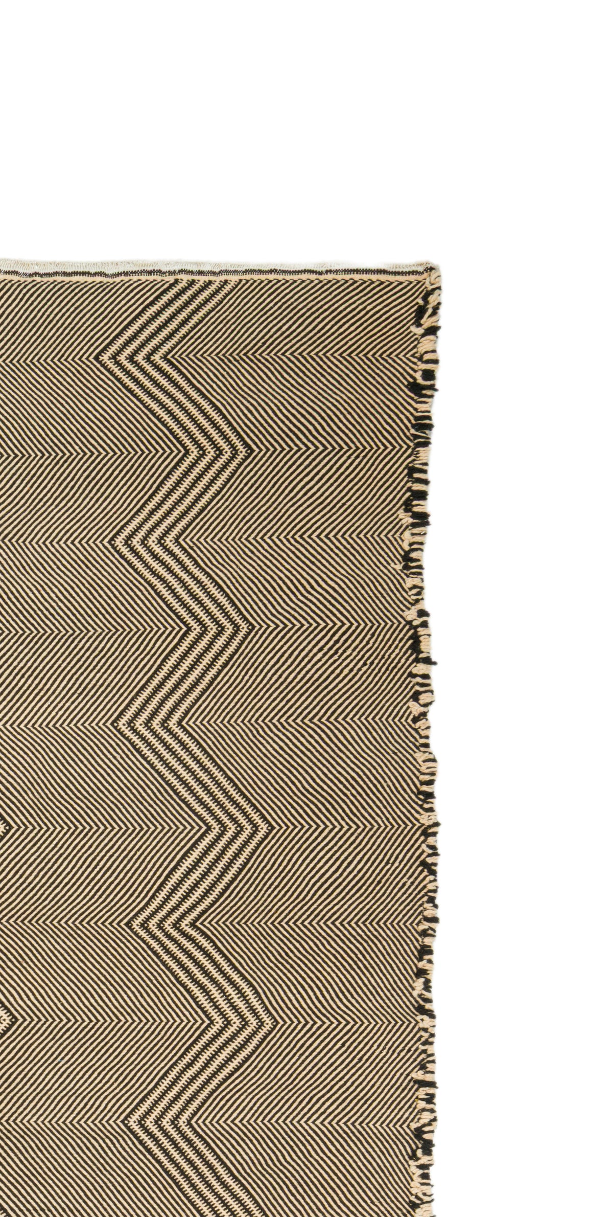 Close-up of a zanafi rug with a beige and brown zigzag herringbone pattern and fringed edges on a white background.