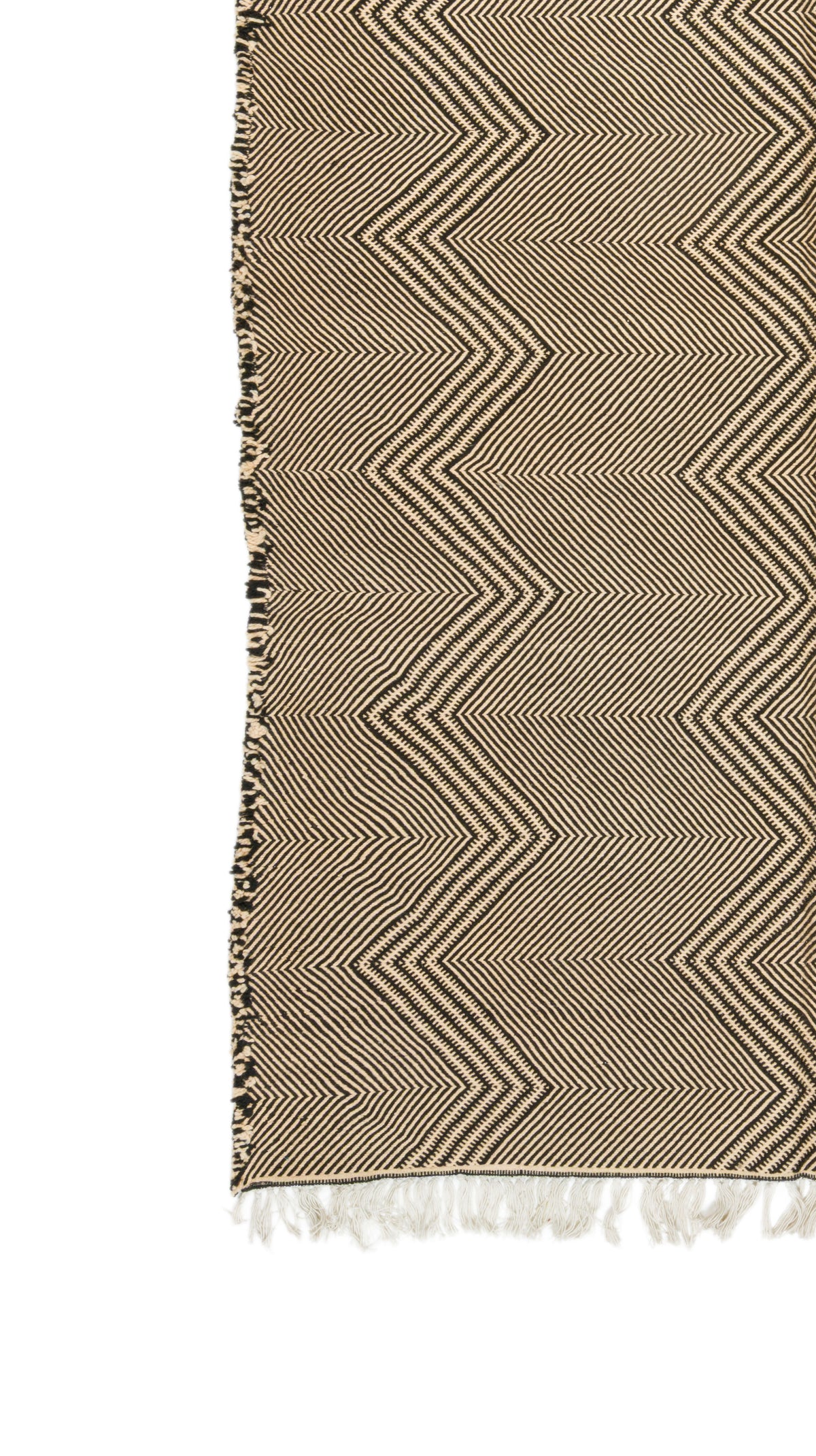 A close-up of a woven textile with a beige and brown zigzag herringbone pattern and white fringe along one edge, shown against a white background.