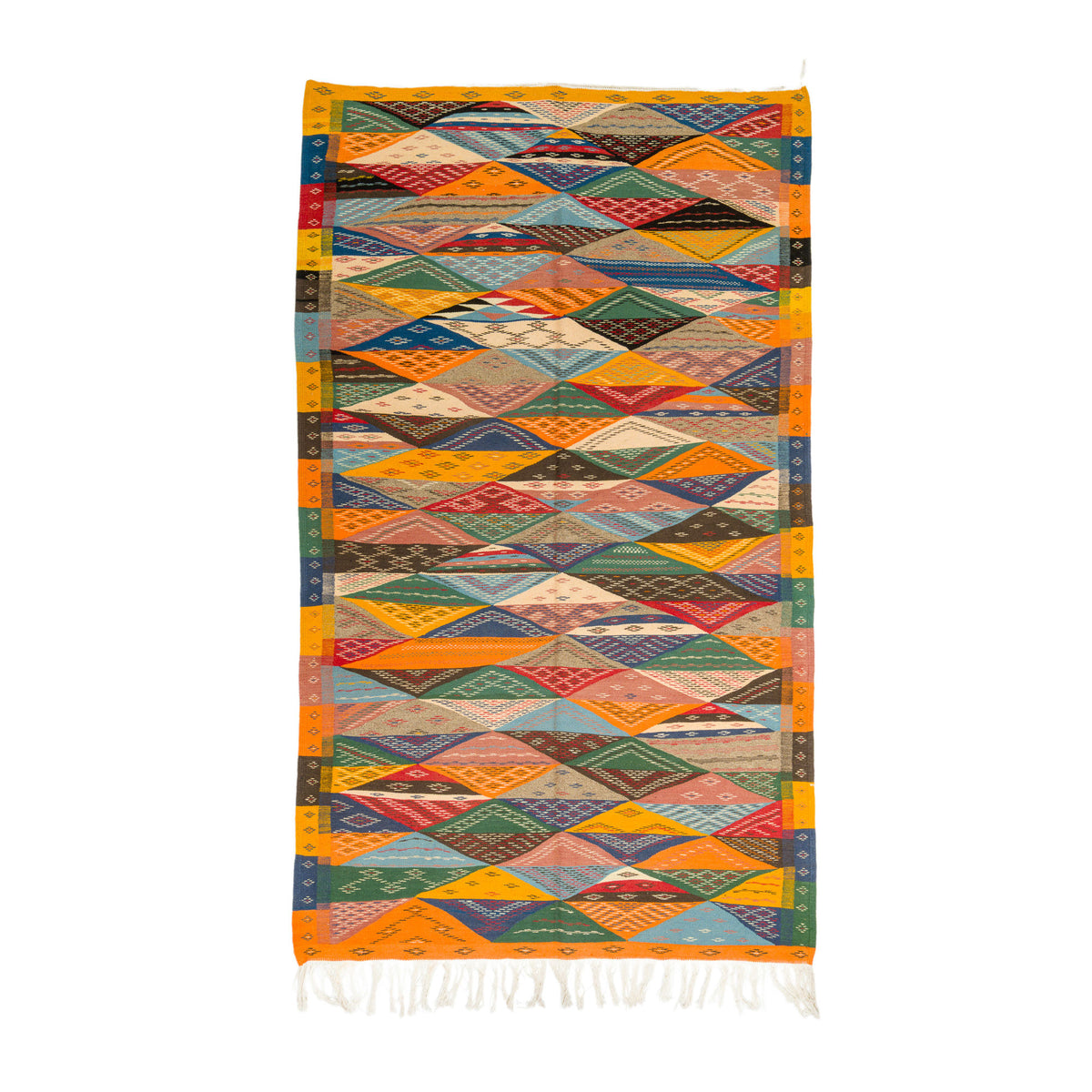 A rectangular handwoven cubist moroccan  rug with a vibrant geometric diamond pattern in orange, yellow, green, blue, red, and brown, finished with white fringe at the bottom, shown flat on a white background.