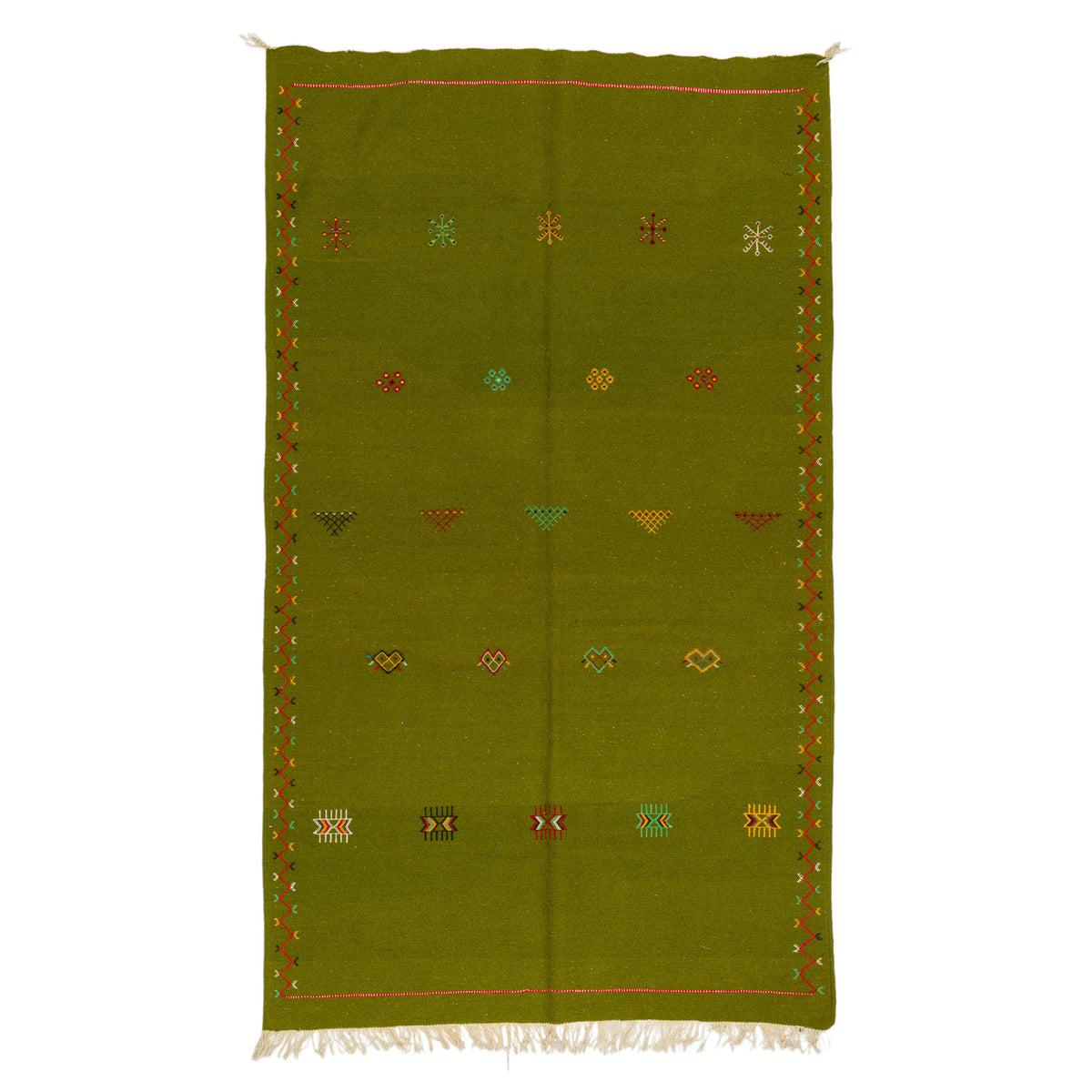 An olive green handwoven moroccan wool rug with a geometric pattern of small embroidered colored motifs and white fringe at the bottom, shown flat against a white background.