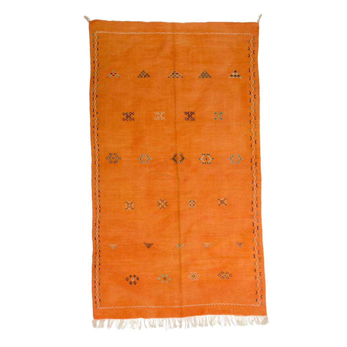 An orange Moroccan wool rug with a geometric hand embroidered tribal motifs and white fringe, shown flat against a white background.