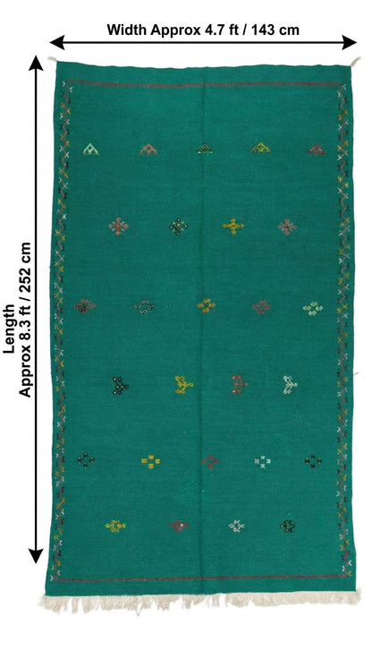 A green handwoven moroccan area rug with a geometric pattern and fringe, shown with dimension arrows indicating a width of approximately 4.7 ft (143 cm) and a length of approximately 8.