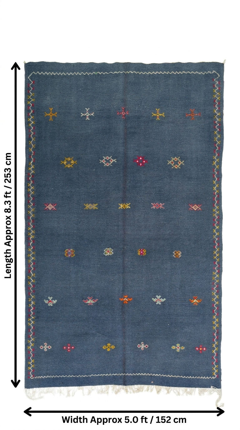 A denim blue moroccan wool rug with colorful embroidered geometric patterns and fringe, shown with dimension lines indicating a length of approximately 8.3 ft (253 cm) and a width of approximately 5.