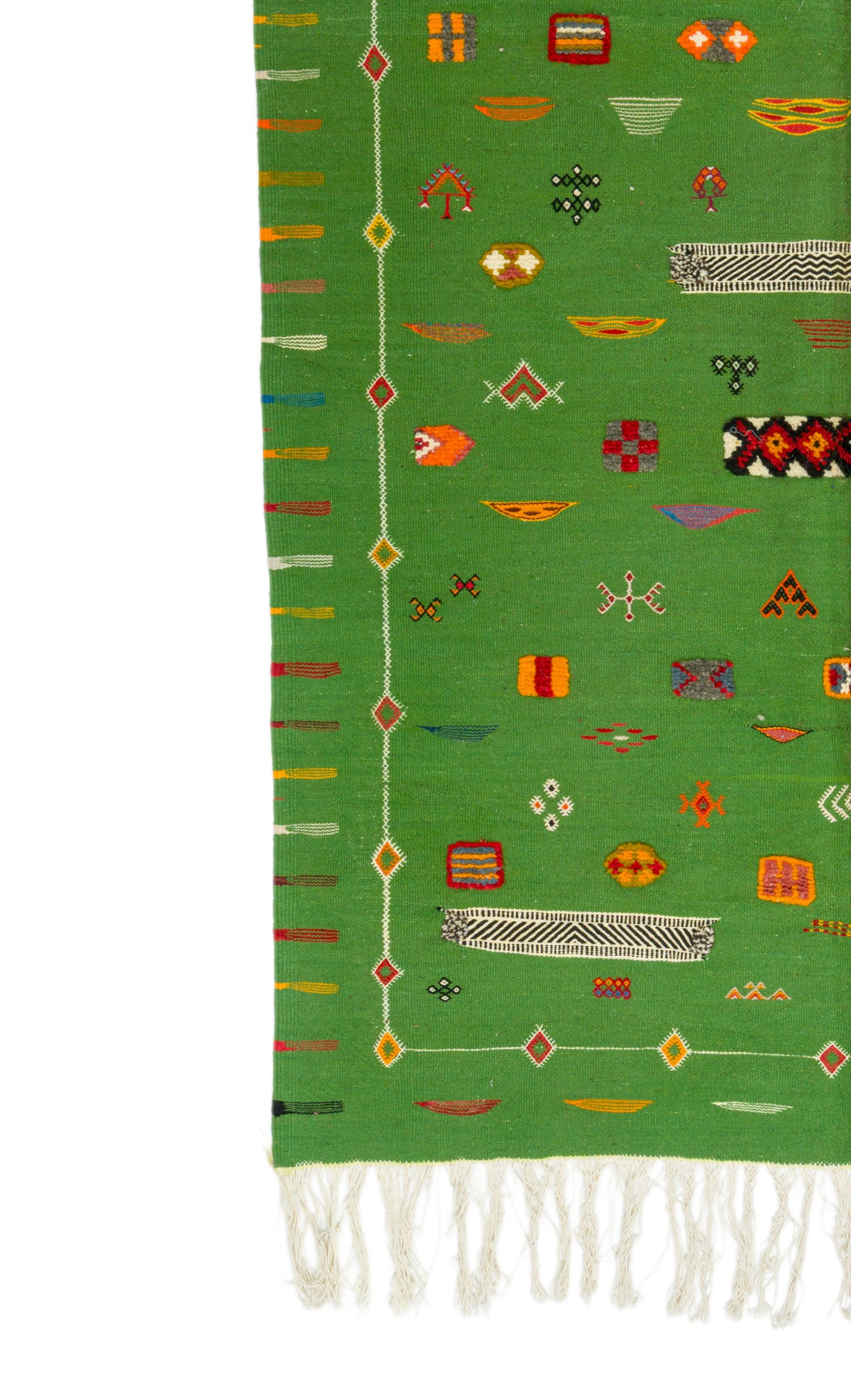A close-up of a green moroccan rug with multicolored geometric motifs and white fringe along one end, shown against a white background.
