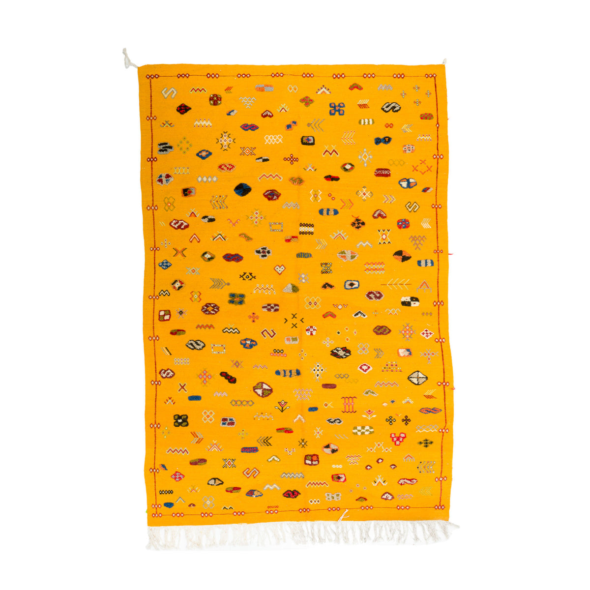 A vibrant yellow Moroccan rug with intricate multicolor geometric patterns and white fringe at the bottom, displayed flat against a white background.