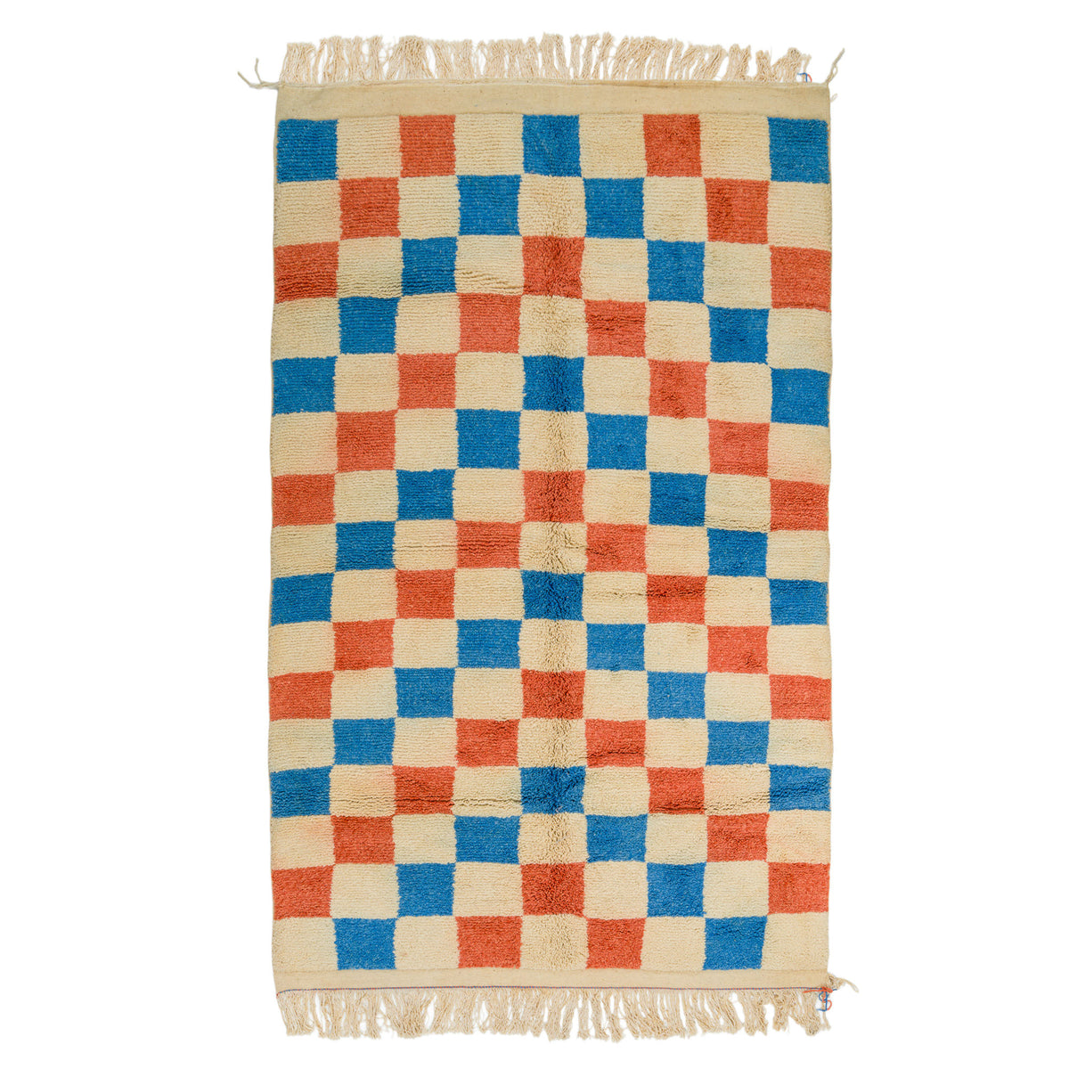 A rectangular woven rug with a checkerboard pattern in blue, orange, and cream, featuring cream fringe on the top and bottom edges. Moroccan rug, carpet.