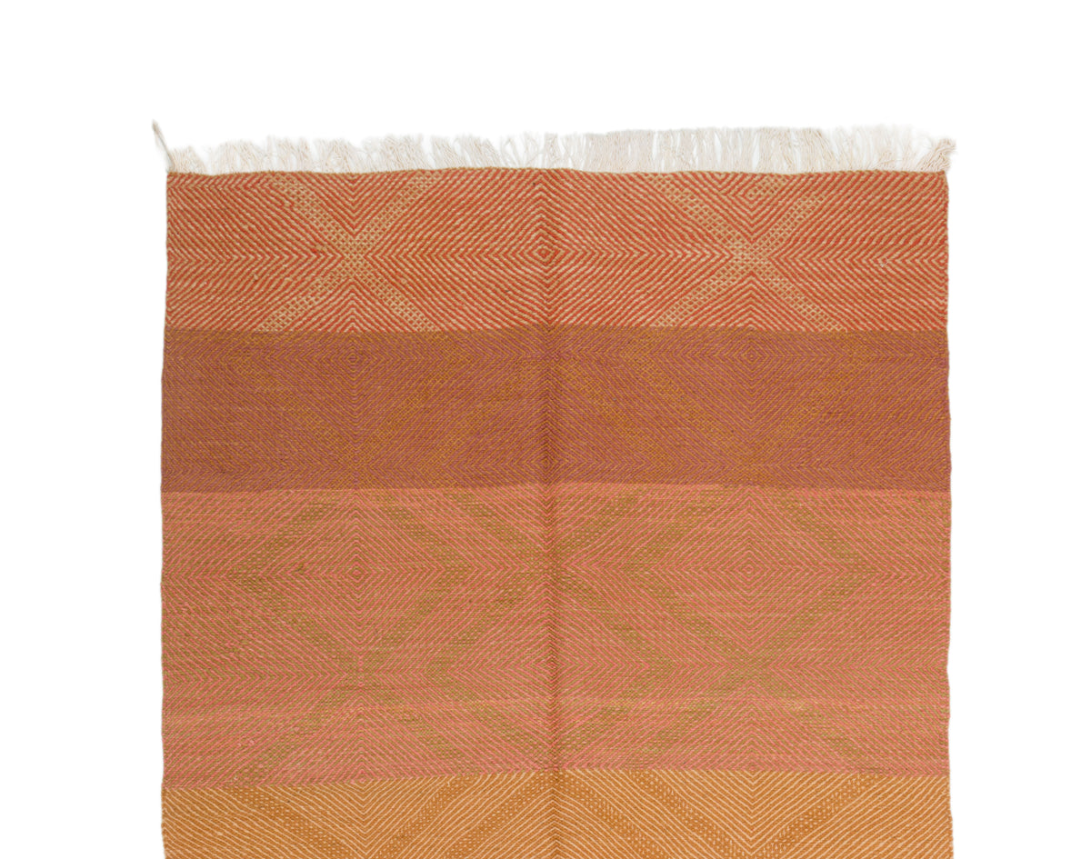 A rectangular wool Zanafi rug with horizontal bands in terracotta, peach, and golden yellow, featuring a subtle geometric pattern and white fringe along the top edge, shown against a plain white background.