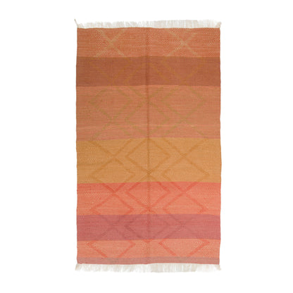 A rectangular Zanafi Wool rug with horizontal stripes in terracotta, orange, mustard yellow, coral pink, and dusty rose, featuring a subtle diamond pattern and white fringe on the top and bottom edges, shown flat against a white background. Moroccan rug.