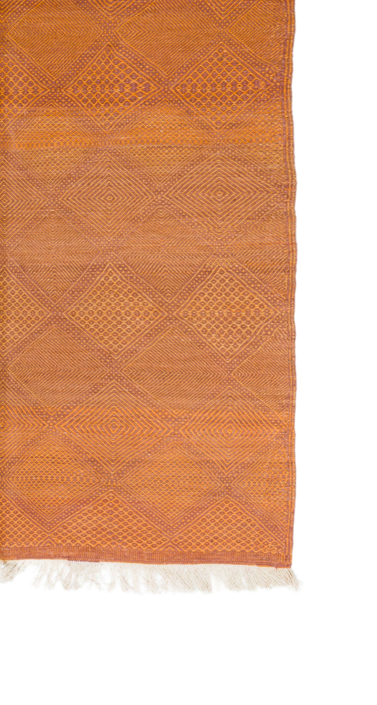 An orange woven textile with a geometric diamond pattern and white fringe along one edge, shown against a plain white background.