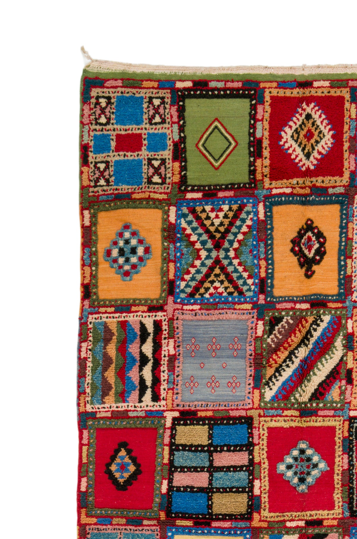 A close-up of a colorful patchwork-style woven rug or textile with multiple square panels in red, blue, green, yellow, orange, and black geometric patterns on a white background.
