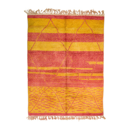 A Beni Ourain wool rug with fringed edges, featuring horizontal stripes in mustard yellow, coral pink, and red, with a geometric diamond pattern. A Moroccan classic rug.