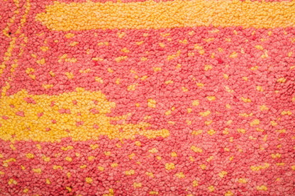 A close-up of a Beni Ourain rug in pink and yellow. 