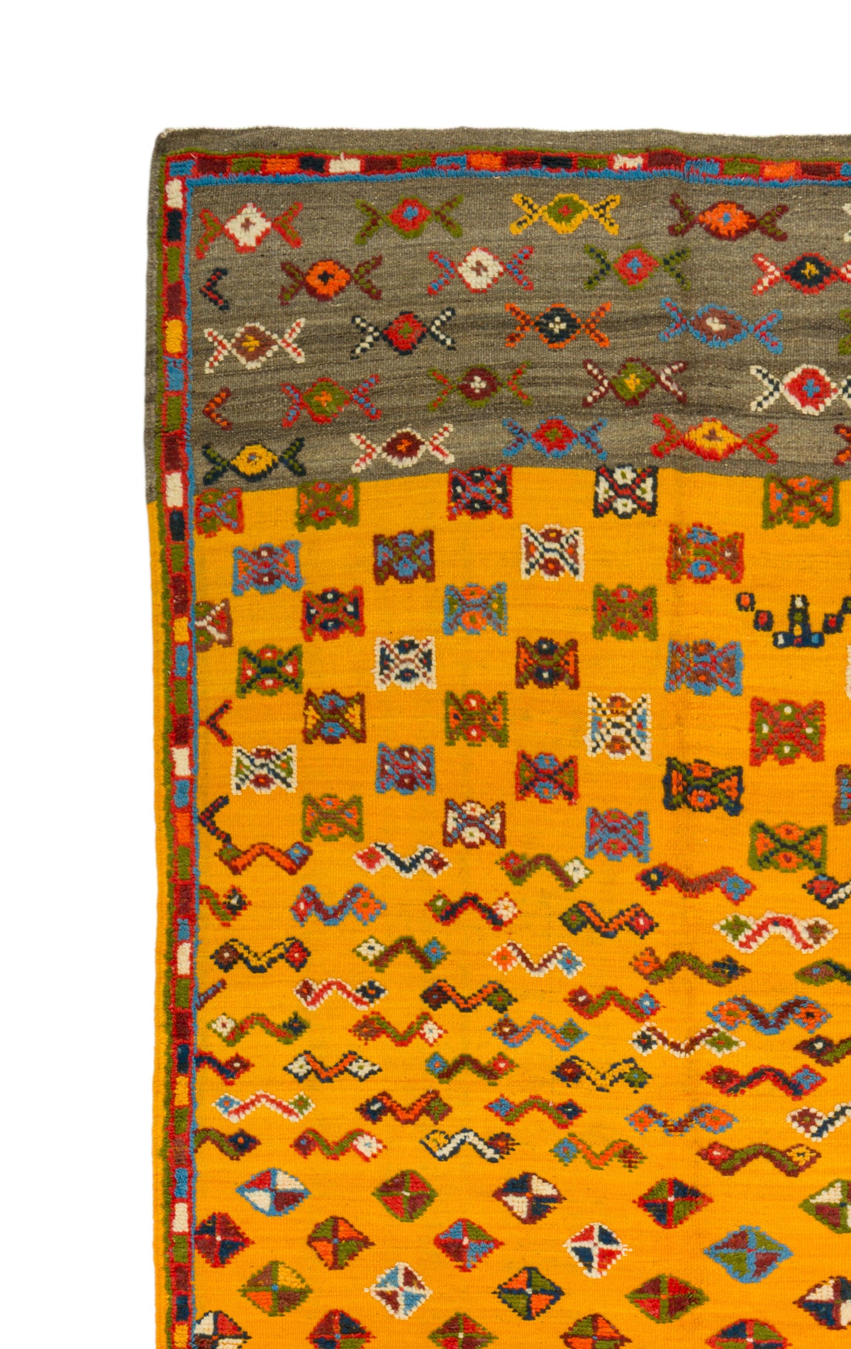 A close-up of a patterned rug showing a mustard yellow field with rows of multicolored geometric and zigzag motifs, plus a gray upper border with repeating decorative symbols.