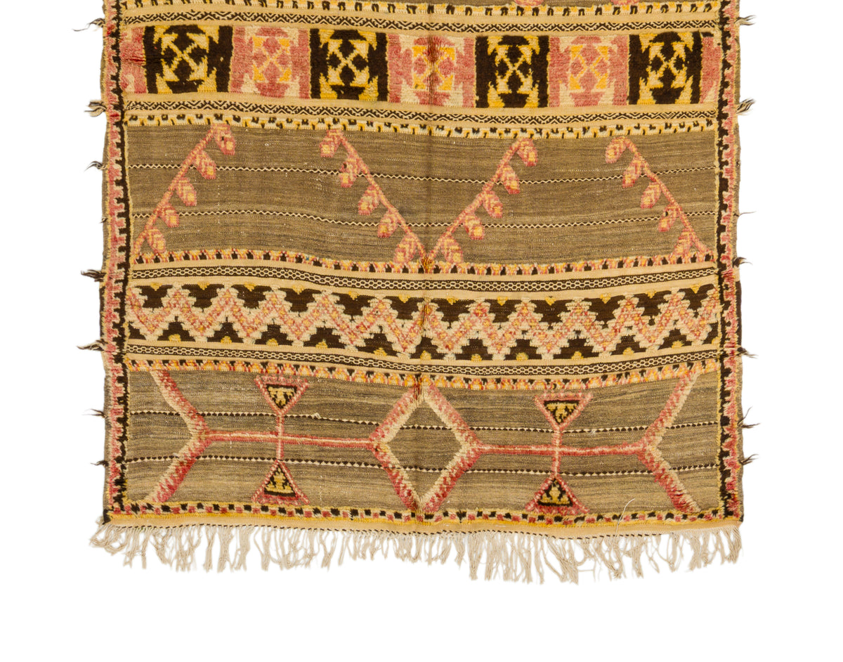 A vintage moroccan kilim rug featuring geometric and tribal-inspired patterns in beige, brown, orange, and black on a white background.