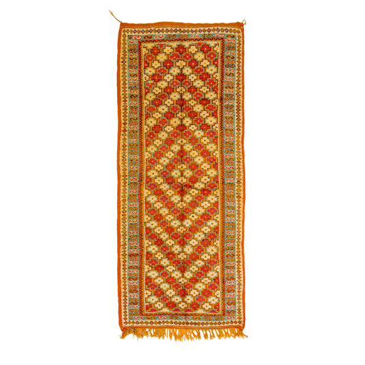 This one-of-a-kind 1970s vintage Moroccan wool runner rug was hand-knotted by a Berber woman artisan in the High Atlas Mountains of Morocco using traditional Taznakht rug-making techniques.