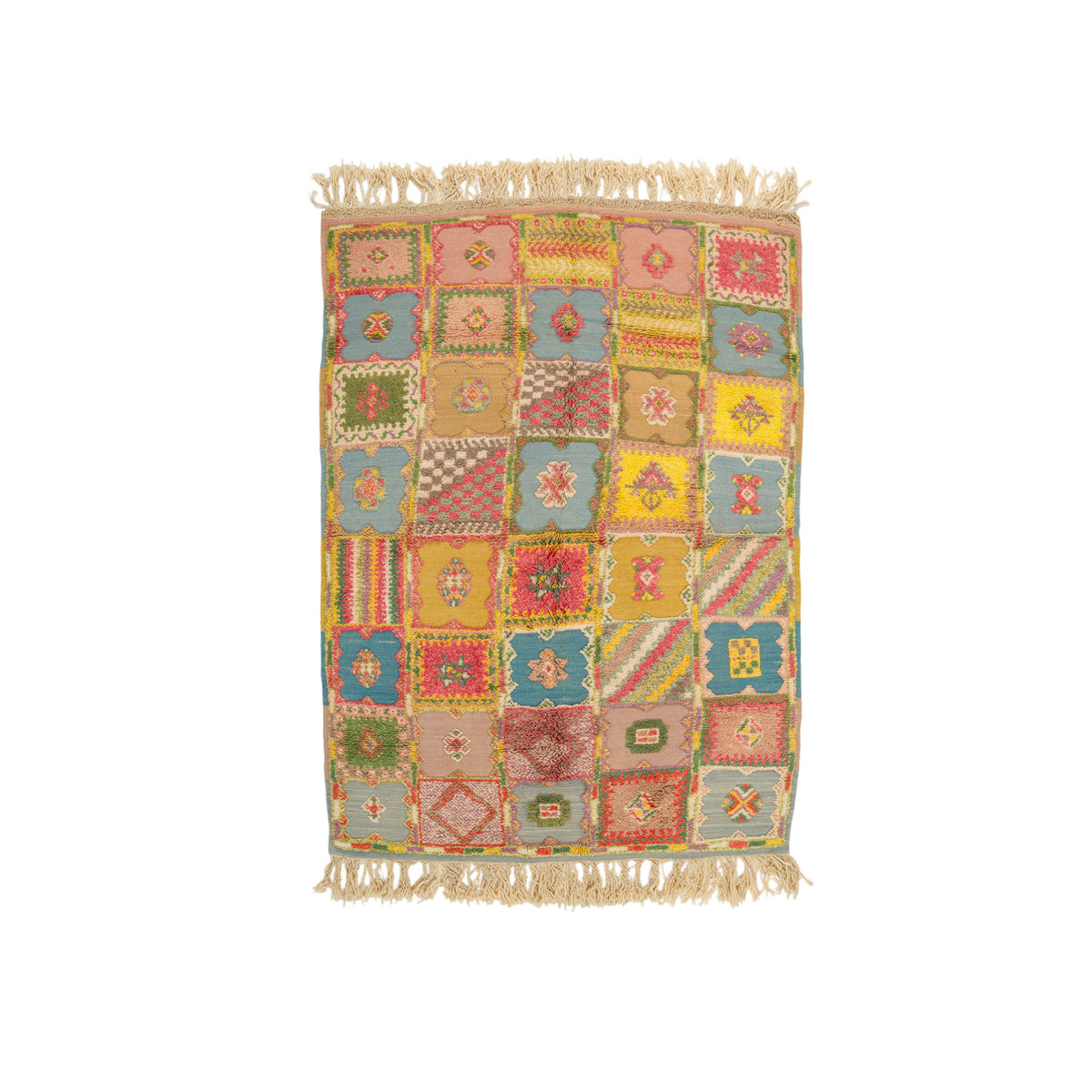 A rectangular patchwork-style moroccan rug with fringed top and bottom edges, featuring a multicolor grid of geometric and floral motifs in pink, yellow, blue, green, and beige tones on a white background.