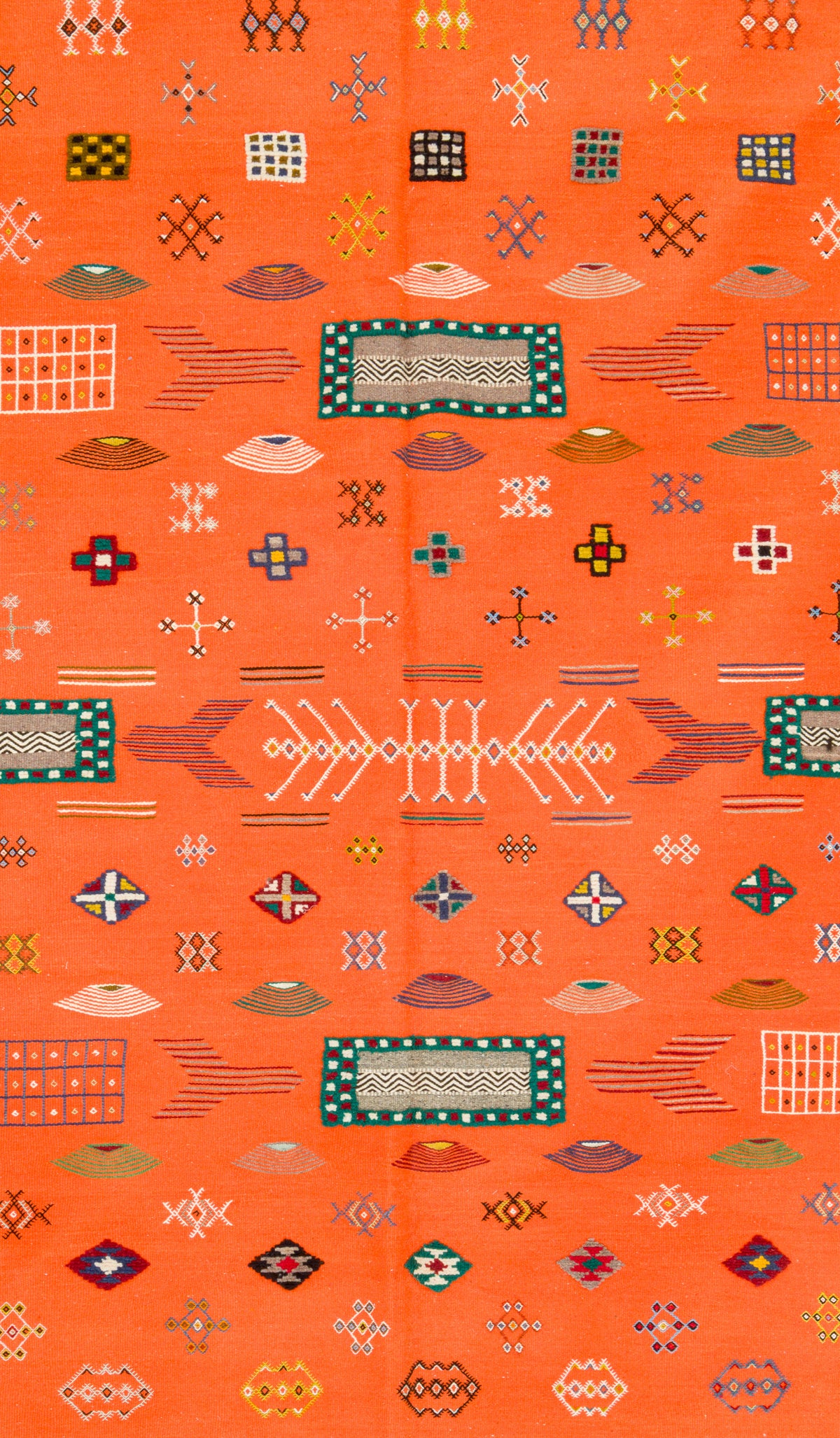 A close-up of a rug featuring a vibrant orange base with a dense, repeating geometric pattern in teal, red, beige, yellow, and white.