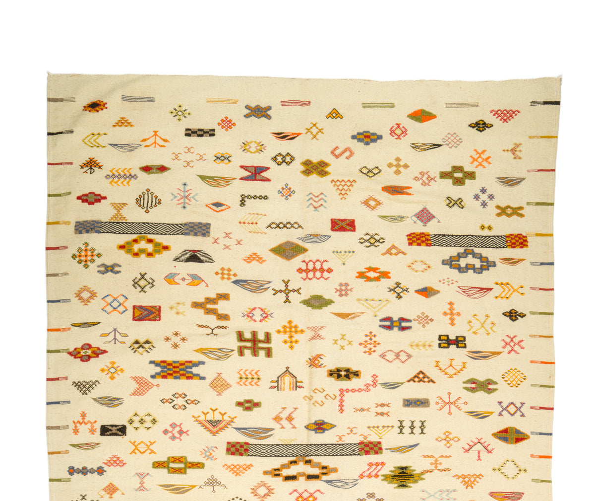 A Moroccan Kilim wool rug with an off-white base and dense geometric patterns in orange, brown, olive green, gray, and black, photographed flat against a white background.