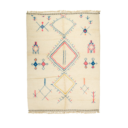 A rectangular cream-colored Moroccan rug with geometric diamond and cross motifs in red, blue, and yellow, finished with fringed edges.