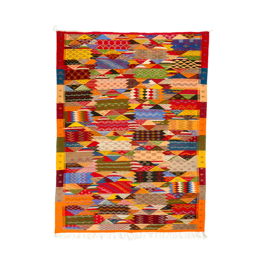 A square moroccan rug from taznakht with a vibrant, multicolor geometric cubist pattern and white fringe on the bottom edge, displayed flat against a solid white background.