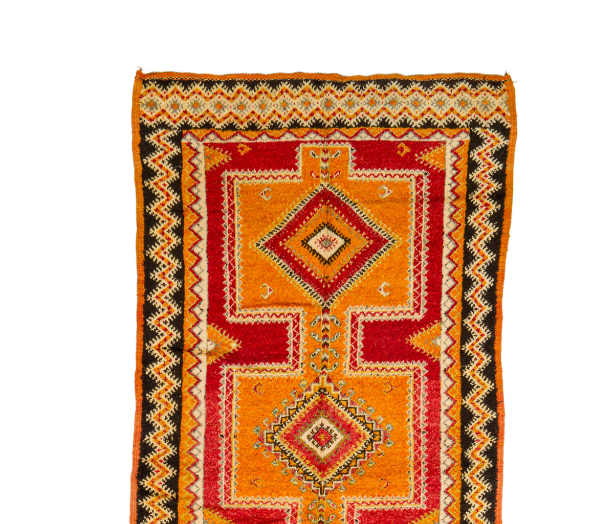 A vintage Moroccan wool rug with a geometric pattern in orange, red, black, and beige, shown flat against a white background.