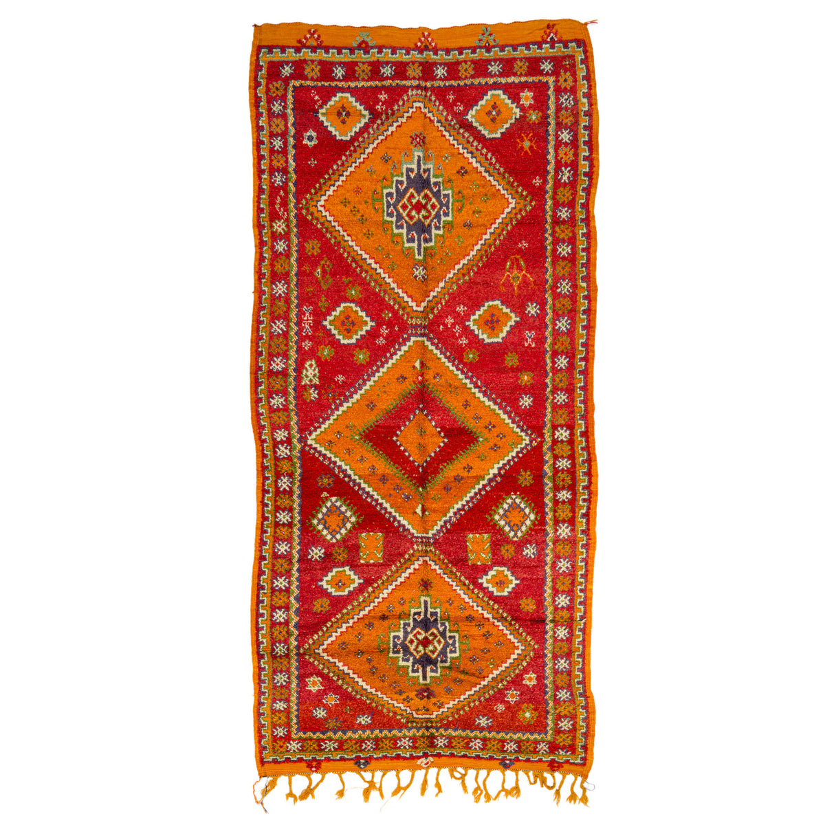 A traditional handwoven wool runner rug with a vibrant red field, three large central orange diamond medallions, and a thick orange border, finished with yellow fringe tassels at the bottom.
