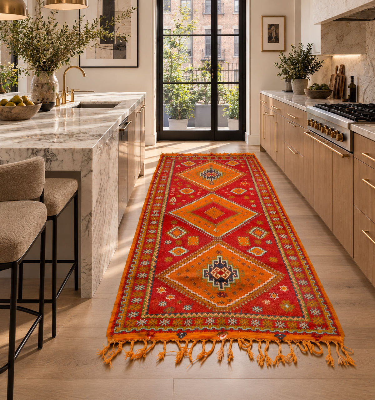 A long red and orange patterned Moroccan vintage runner rug with fringe tassels is displayed in a bright, modern kitchen hallway.