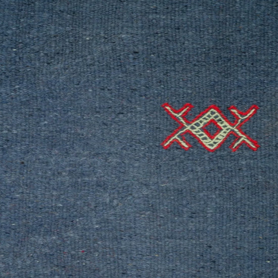 close-up view of a blue moroccan rug handwoven with hand embroidered tribal motifs