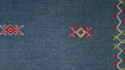 close-up view of a blue moroccan rug handwoven with hand embroidered tribal motifs