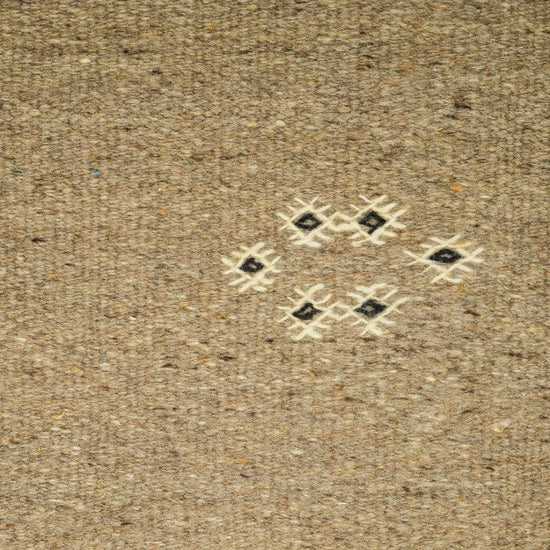 close-up video of a moroccan rug handwoven and hand embroidered with  small tribal motifs