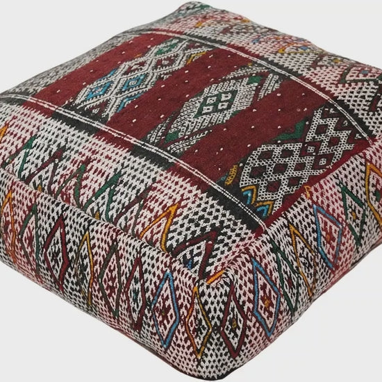 Video of vintage Moroccan kilim pouf  deep red tribal showing texture and Berber details 