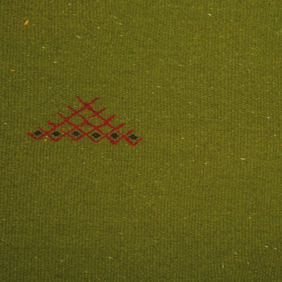 close-up video of green moroccan rug handwoven and hand embroidered with tribal motifs