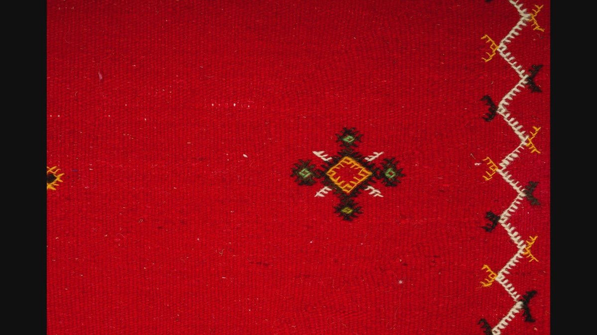 close-up video of moroccan rug red handwoven with hand embroidered tribal motifs
