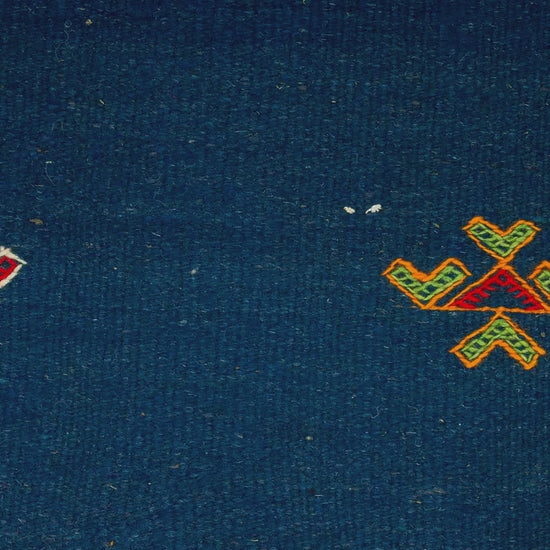 close-up video of blue moroccan rug handwoven hand embroidered with tribal motifs