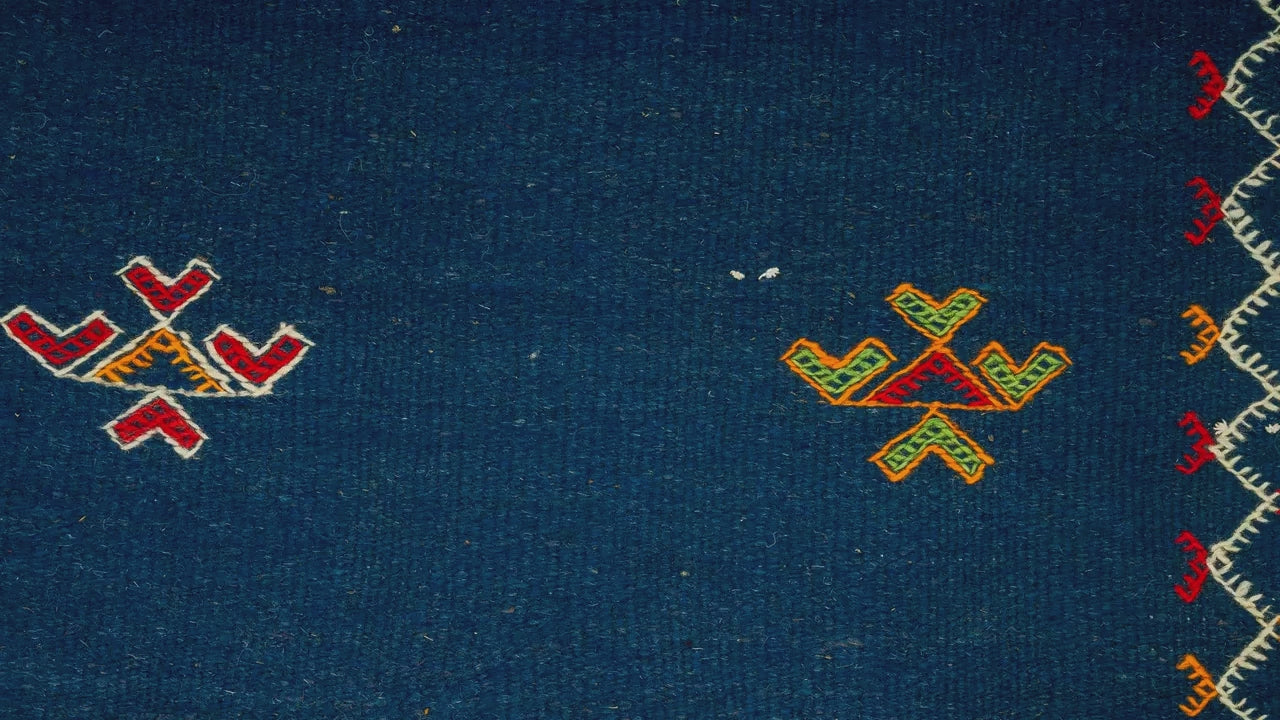 close-up video of blue moroccan rug handwoven hand embroidered with tribal motifs