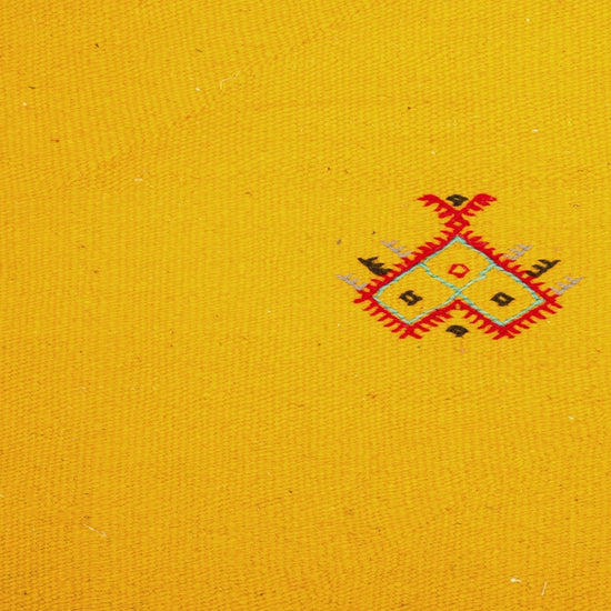 close-up video of a yellow moroccan rug handwoven with hand embroidered motifs