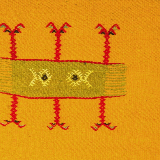 close-up video of a yellow moroccan rug handwoven with hand embroidered tribal motif