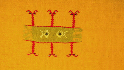 close-up video of a yellow moroccan rug handwoven with hand embroidered tribal motif