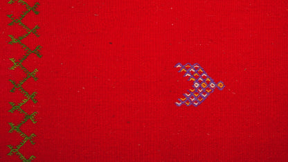 close up video of a red moroccan rug handwoven with hand embroidered tribal motifs